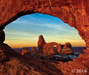 Turret Arch viewed through North Window arch in The Windows Section of Arches National Park. The arches formed as the result of erosion through weak parts of sandstone fins composed of Jurassic-age Dewey Bridge Member of the Carmel Formation and Slick Rock Member of the Entrada Sandstone. Arches National Park, Grand County, Utah Photographer: Gregg Beukelman; © 2014