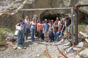 A group of people smiling at a camera, while in front a mine.