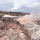 A canopy above rock surface and dust blowing where the dig site is located.