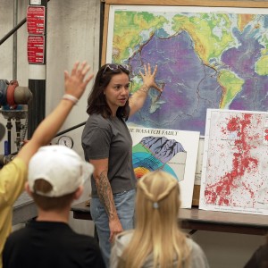 An adult pointing to a map with kids in the foreground.