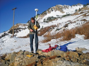 A person taking a GPS survey to map debris flow.