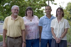 Four people smiling at a camera.