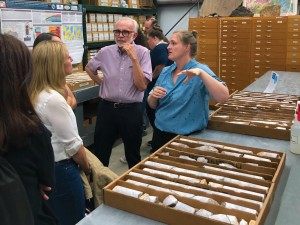 A person explaining to a group of people, with core samples on a tabletop.