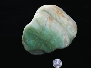 A green dropstone much larger than the quarter for scale.