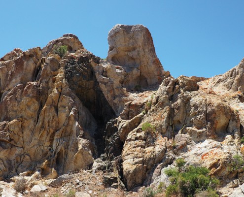 Gray and tan rock outcrop with a black stripe of rock cutting through.