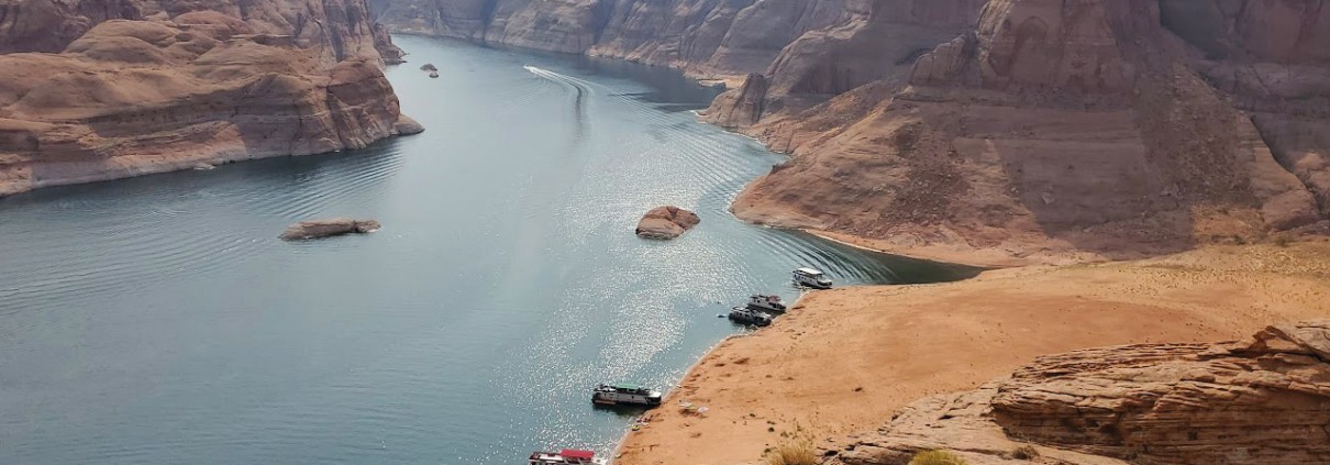 Photo of a red rock landscape with a body of water in the background.